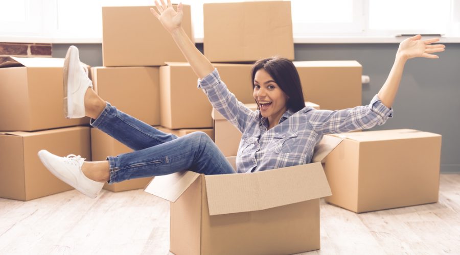 young woman sitting in moving box