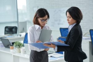 Business lady showing financial report to her coworker