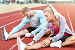 Man and woman stretching before running